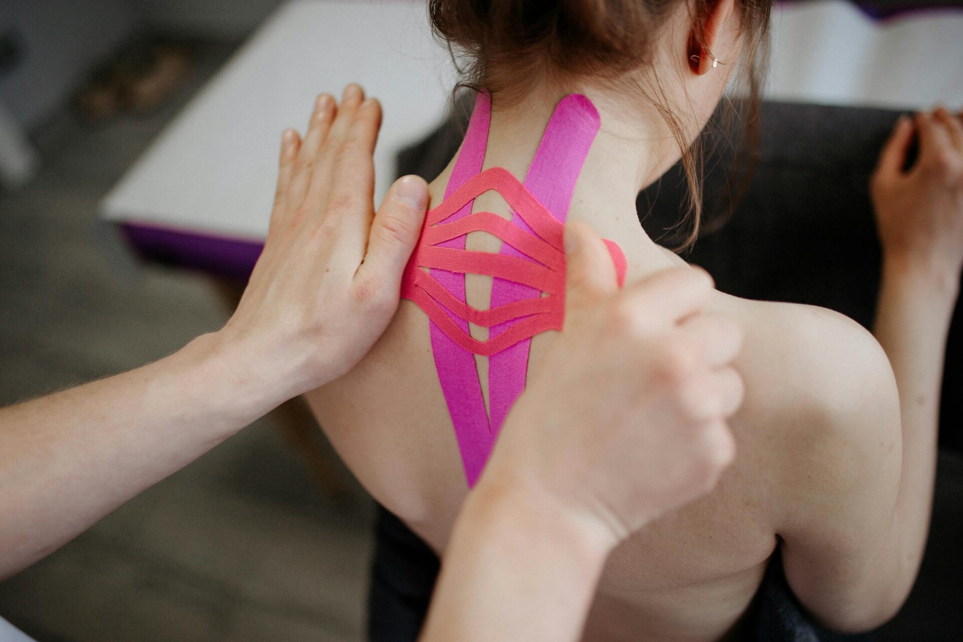 A close-up image of kinesio tape being applied to a person's back, showcasing healthcare and treatment.